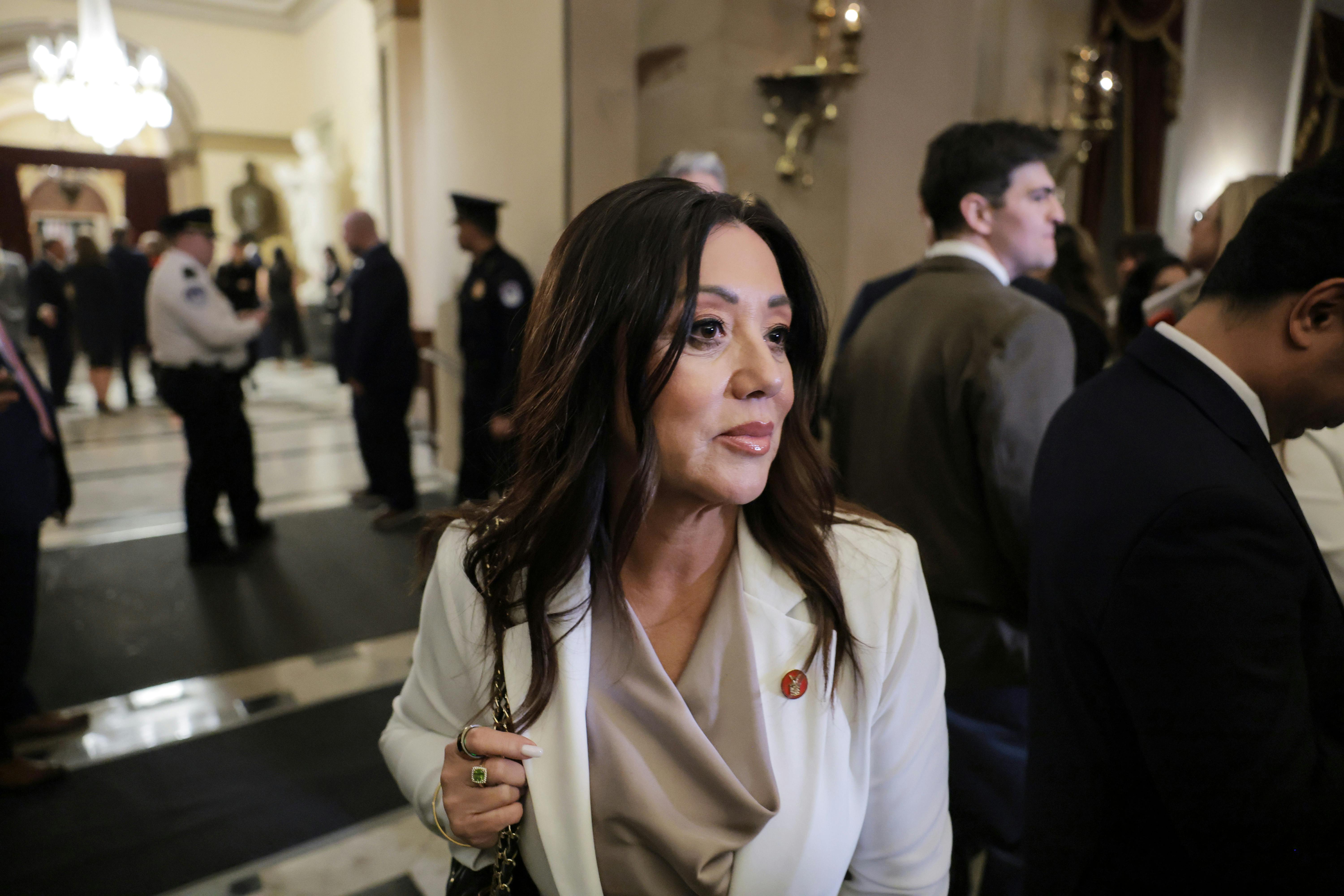 Lori Chavez-DeRemer holds onto her purse as she stands in the Capitol.
