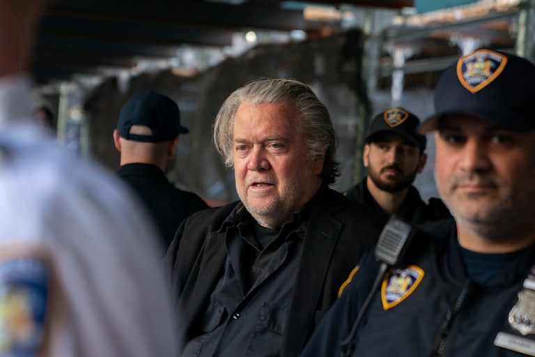 Steve Bannon stands surrounded by security officers