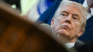Donald Trump sits at his desk in the Oval Office