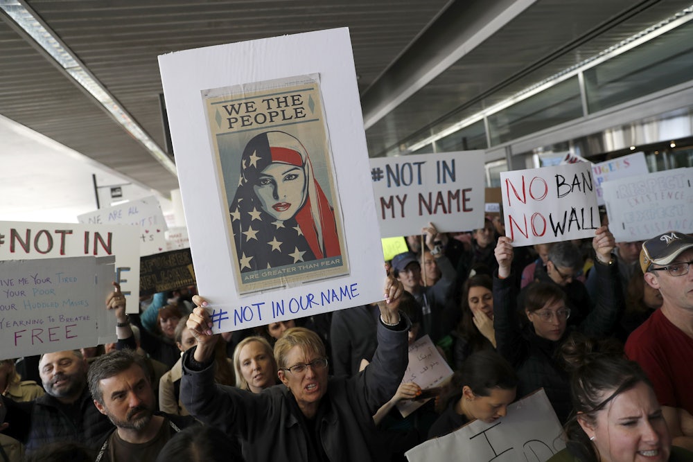 Demonstrators hold signs during a rally against a ban on Muslim immigration on January 28, 2017 in San Francisco, California.