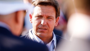 Florida Gov. Ron DeSantis looks at someone talking to him.