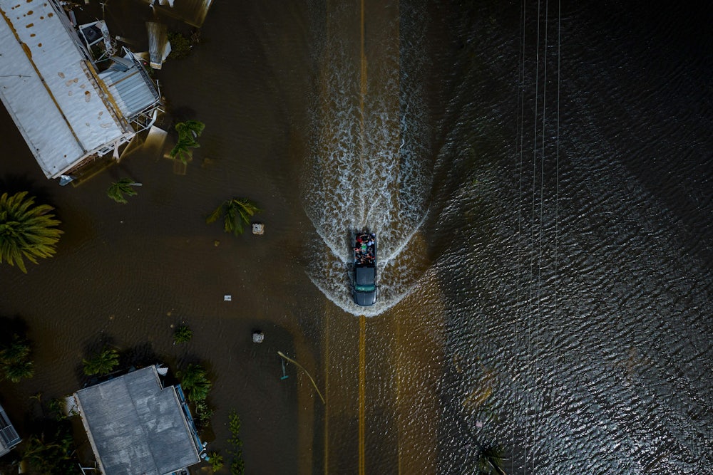 An aerial view shows a car driving through water.