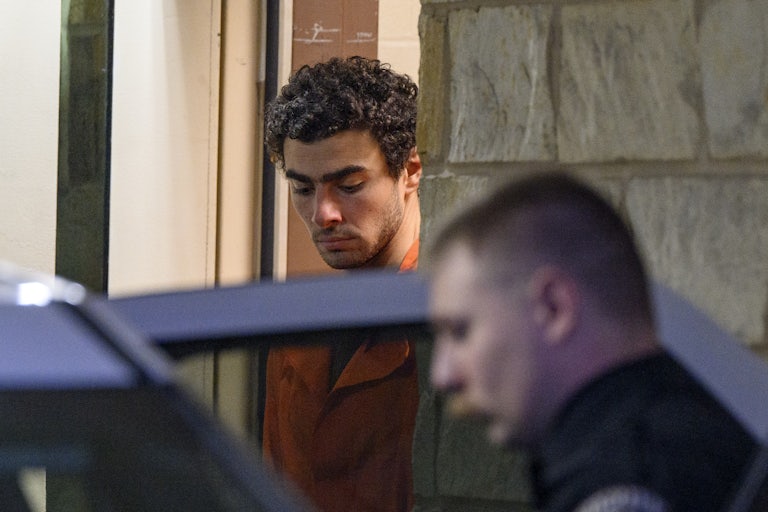 Luigi Mangione looks down while exiting a courthouse