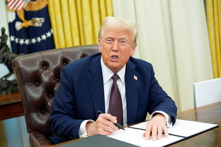 Donald Trump makes a weird face as he prepares to sign an executive order in the Oval Office