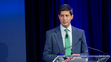 Kevin Warsh speaks at a lectern.