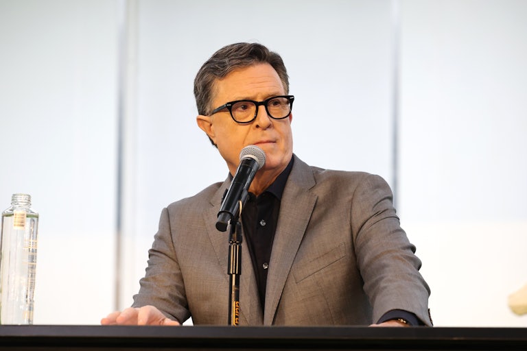 Stephen Colbert stands at a podium