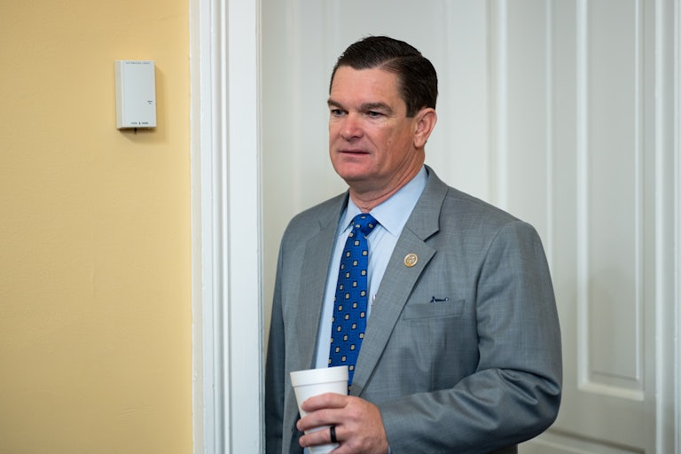 Representative Austin Scott holds a Styrofoam cup while walking in the Capitol