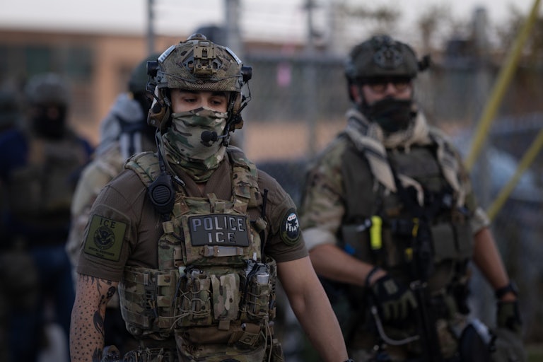 Two ICE agents dressed in full camouflage and masking their face