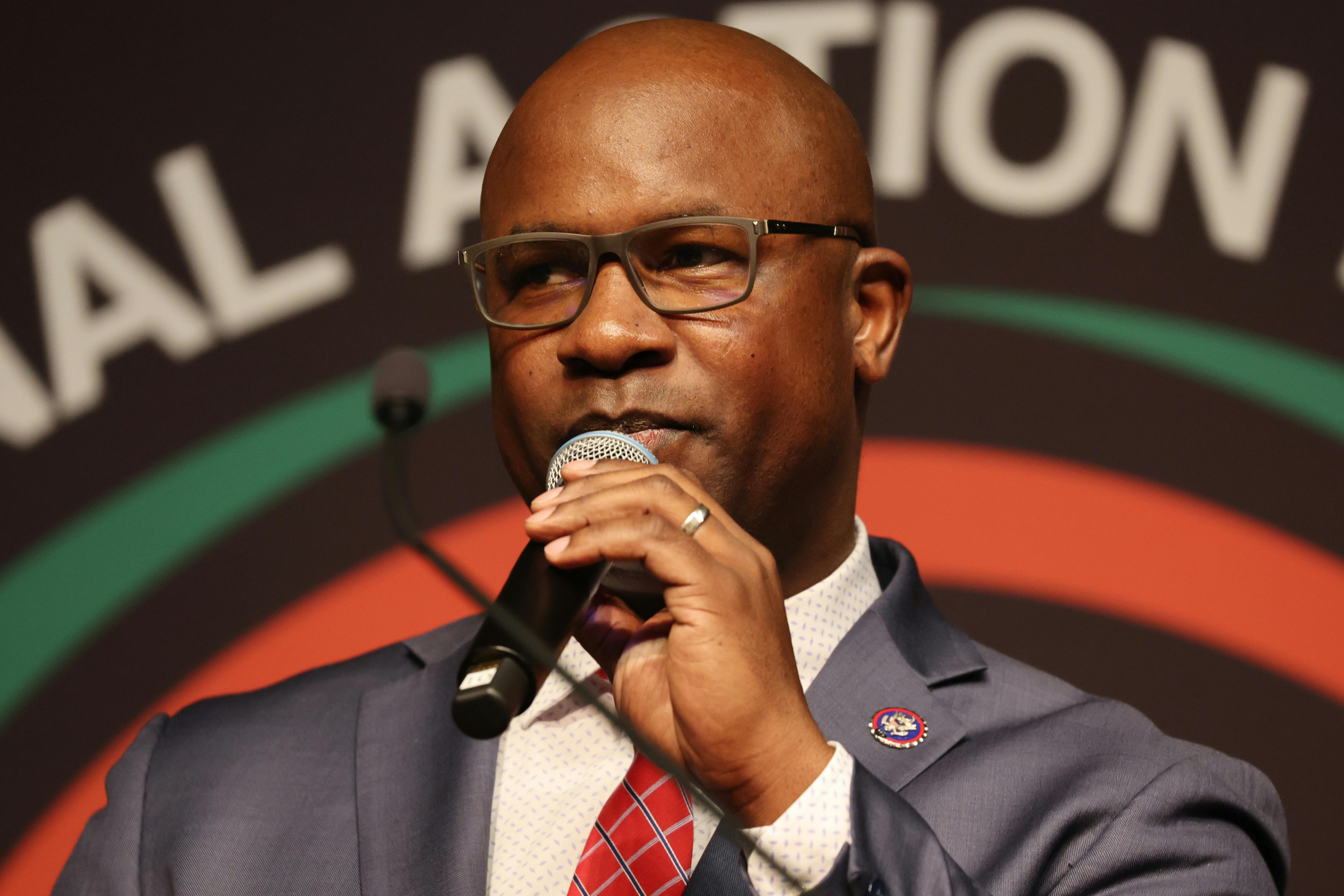 Jamaal Bowman holds a microphone.