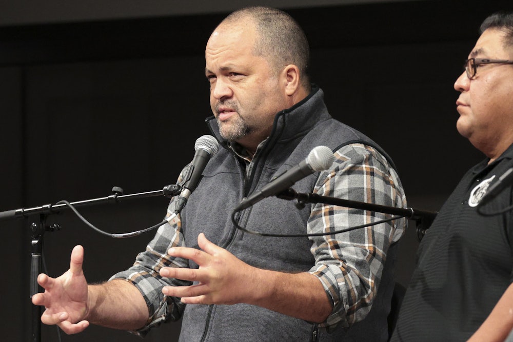 Ben Jealous speaks into a microphone with another person beside him.