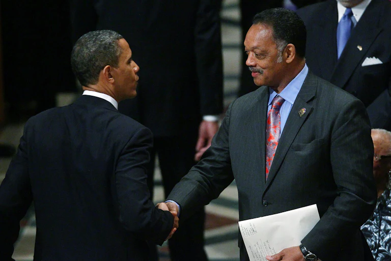 Jesse Jackson shakes hands with Barack Obama.