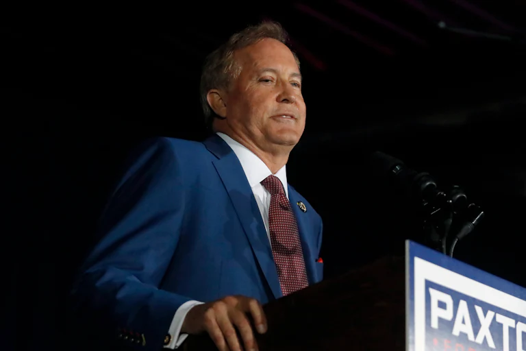 Texas Attorney General Ken Paxton stands at a podium during a Senate campaign event.