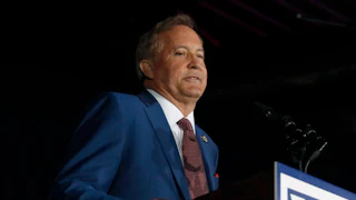 Texas Attorney General Ken Paxton stands at a podium during a Senate campaign event.