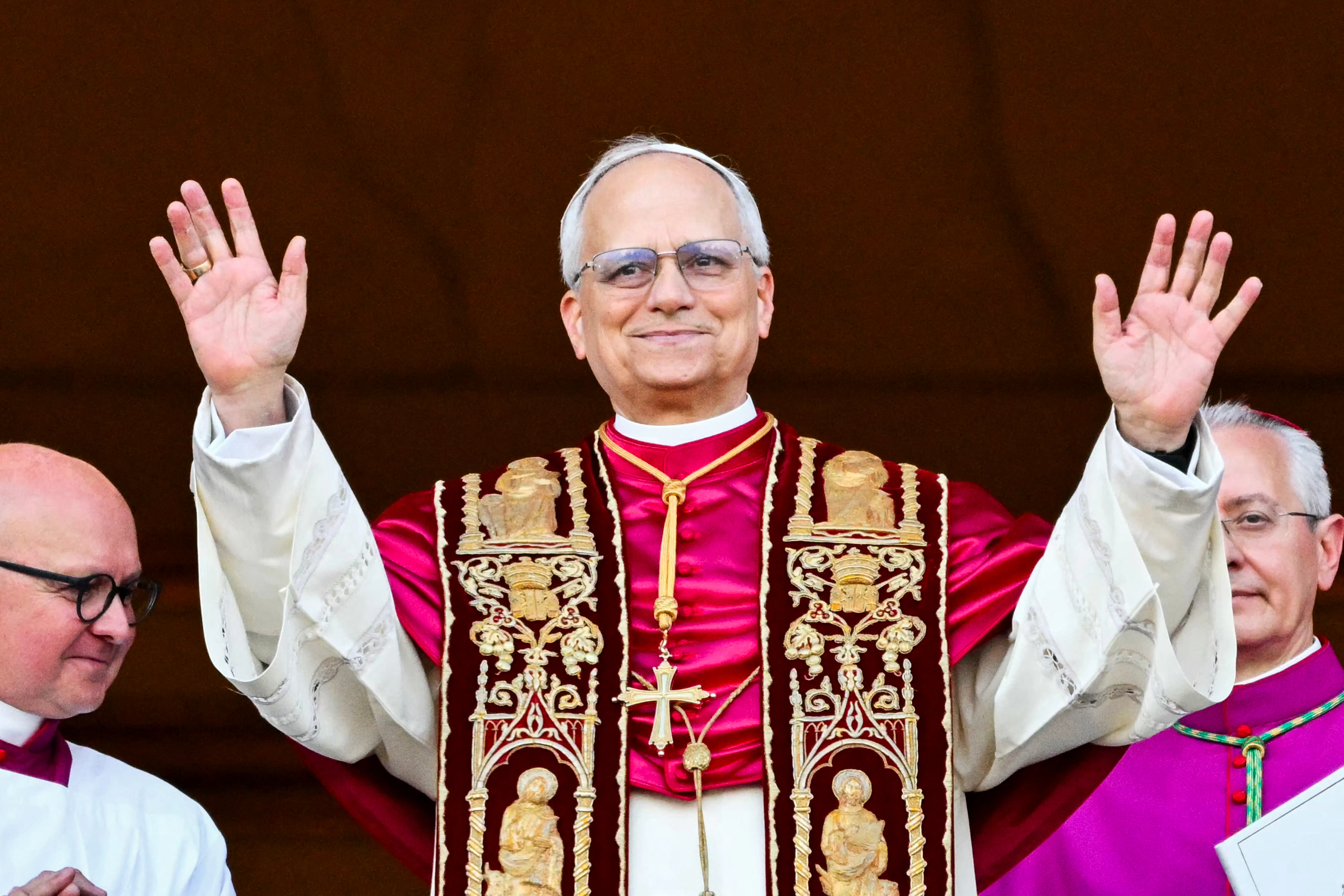 Pope Leo holds up both hands