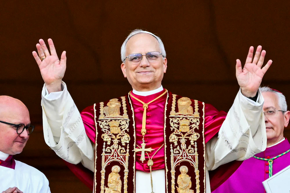 Pope Leo holds up both hands