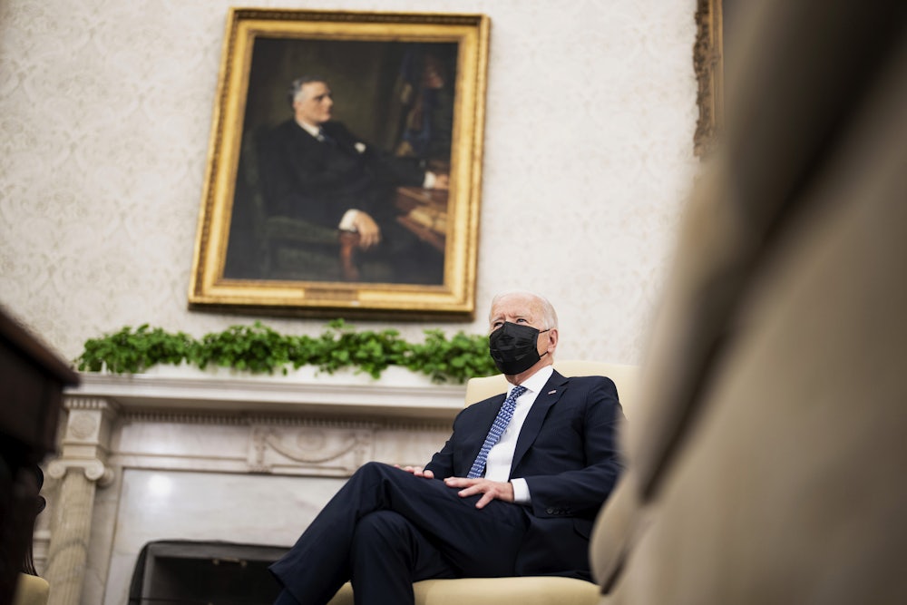 A masked President Joe Biden sits in the Oval Office.