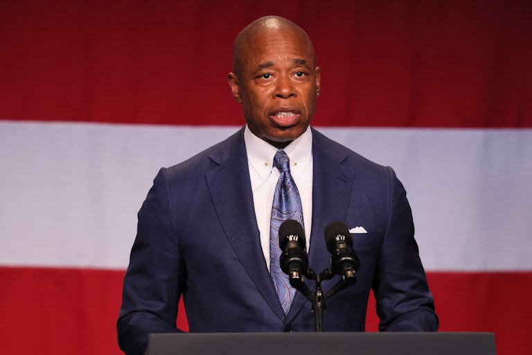 New York City Eric Adams speaking in front of a U.S. flag