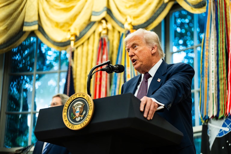 Donald Trump speaks at a podium in the Oval Office