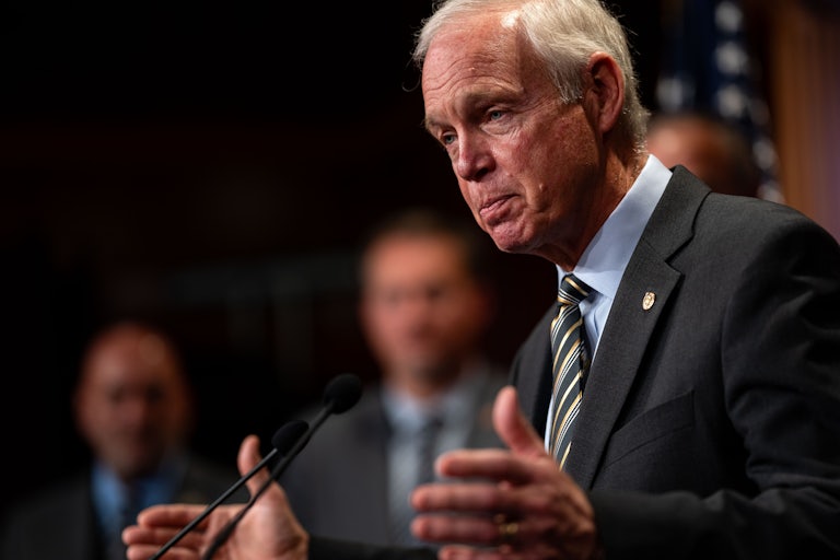 Senator Ron Johnson gestures while speaking at a podium during a press conference