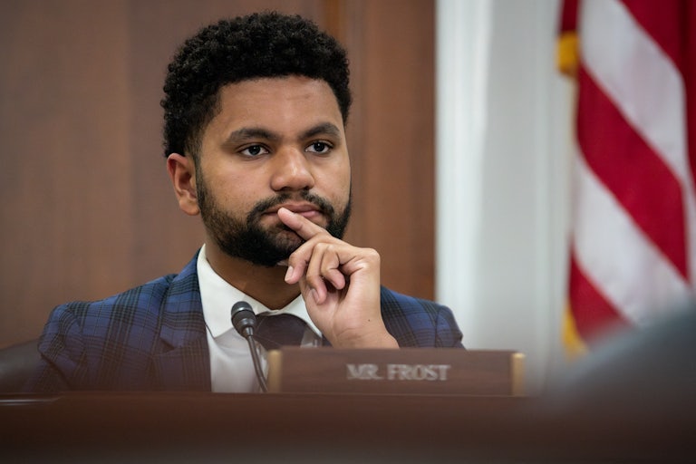 Maxwell Frost holds his hand in front of his mouth
