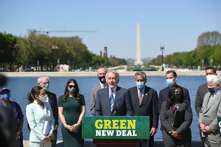 Ed Markey stands with others at a podium that says "Green New Deal."