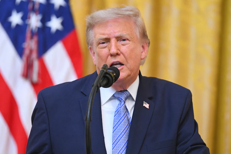 President Donald Trump speaks at the podium in the White House.