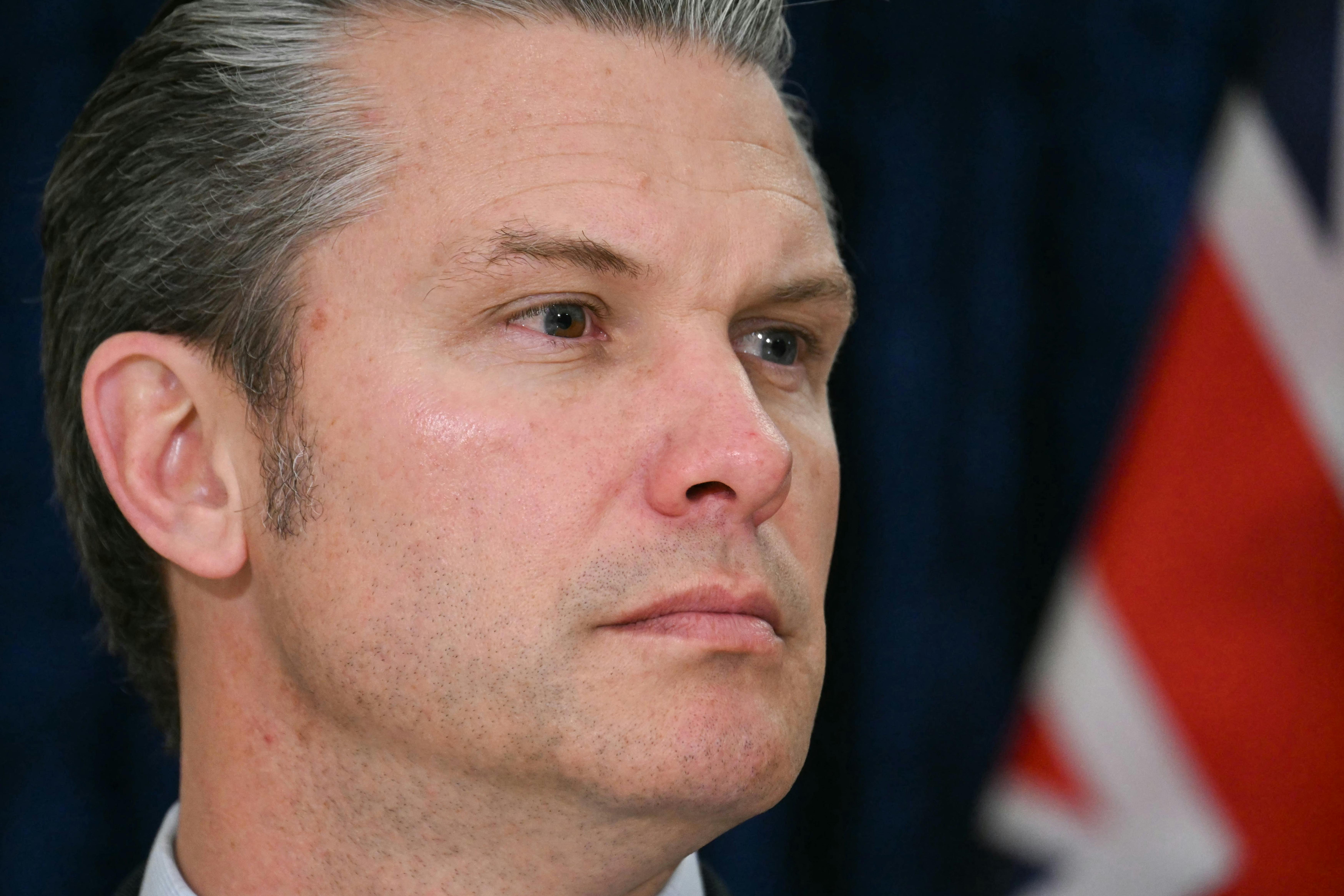 Defense Secretary Pete Hegseth turns his head to the side