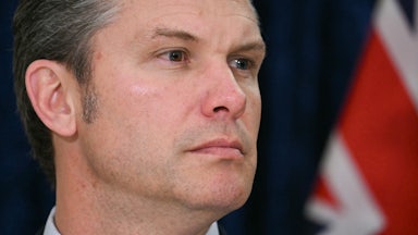 Defense Secretary Pete Hegseth turns his head to the side