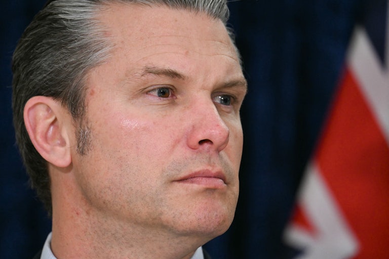 Defense Secretary Pete Hegseth turns his head to the side