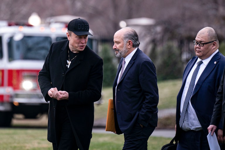 Elon Musk walks and talks to Commerce Secretary Howard Lutnick outside the White House