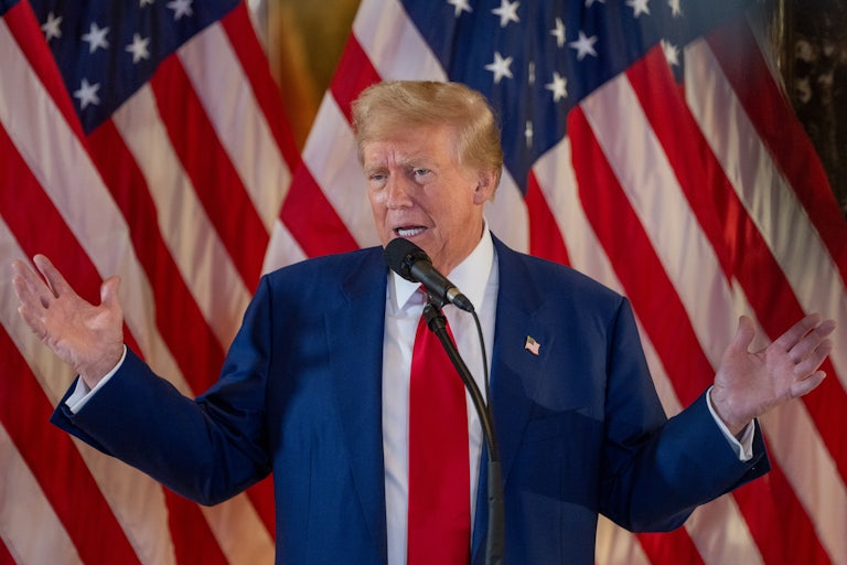 Donald Trump gestures as he speaks into a microphone