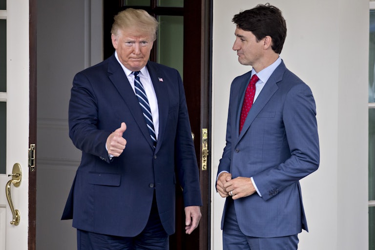 Donald Trump gives a thumbs-up while standing next to Justin Trudeau