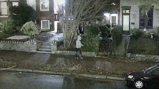 Jan. 6 suspect wears a gray hoodie and a face mask and walks in the streets of Washington, D.C. carrying a bag.