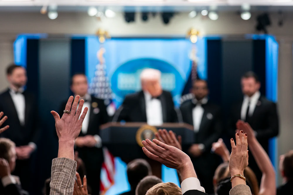 Reporters and members of the media raise their hand to ask a question to President Donald Trump during a press conference in the Brady Briefing Room of the White House following the cancellation of the annual White House Correspondents Association Dinner.