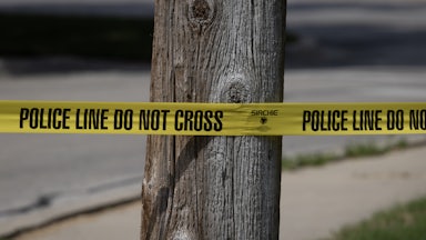 Police tape in front of a tree