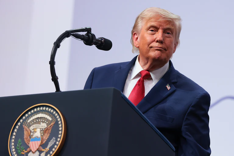 Donald Trump smiles while speaking at the G7 summit.