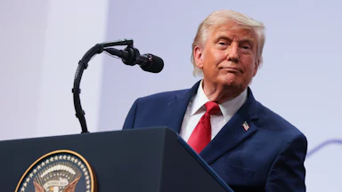 Donald Trump smiles while speaking at the G7 summit.