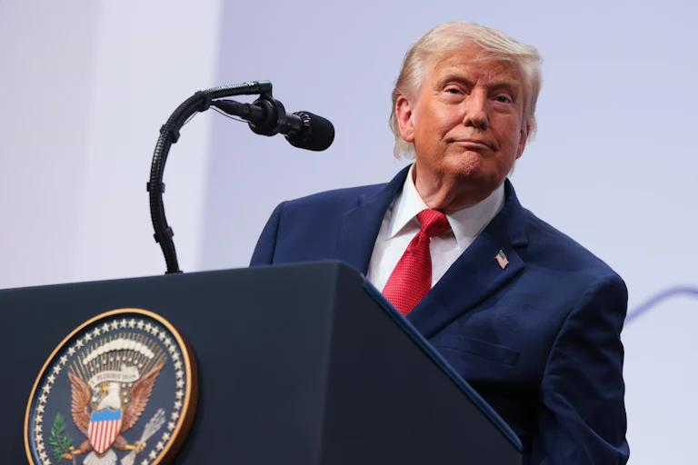Donald Trump smiles while speaking at the G7 summit.