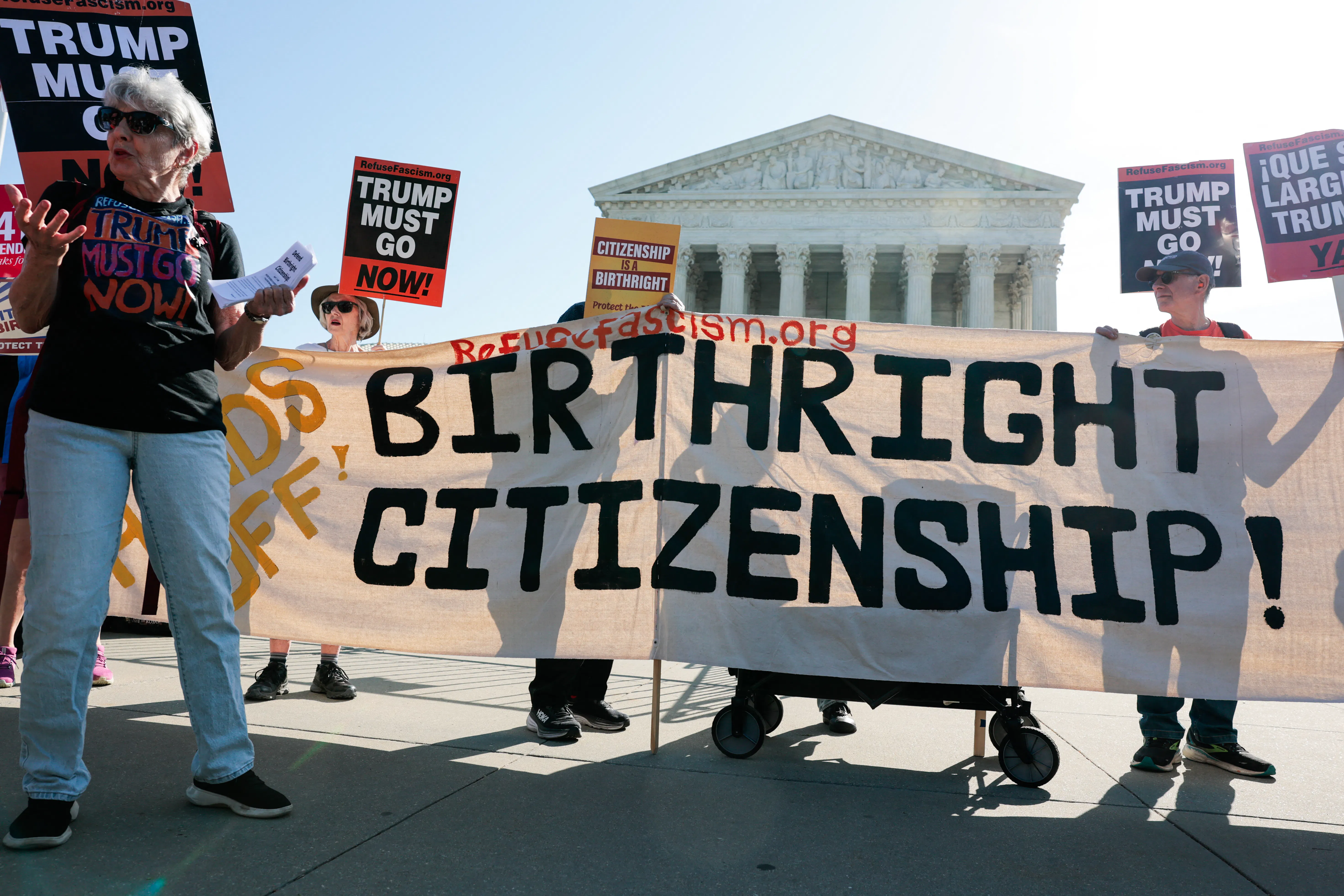 Demonstrators hold signs in support of birthright citizenship outside the Supreme Court.