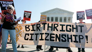 Demonstrators hold signs in support of birthright citizenship outside the Supreme Court.