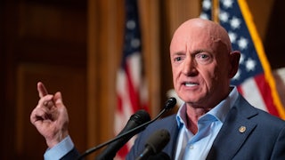 Senator Mark Kelly gestures while speaking at a podium