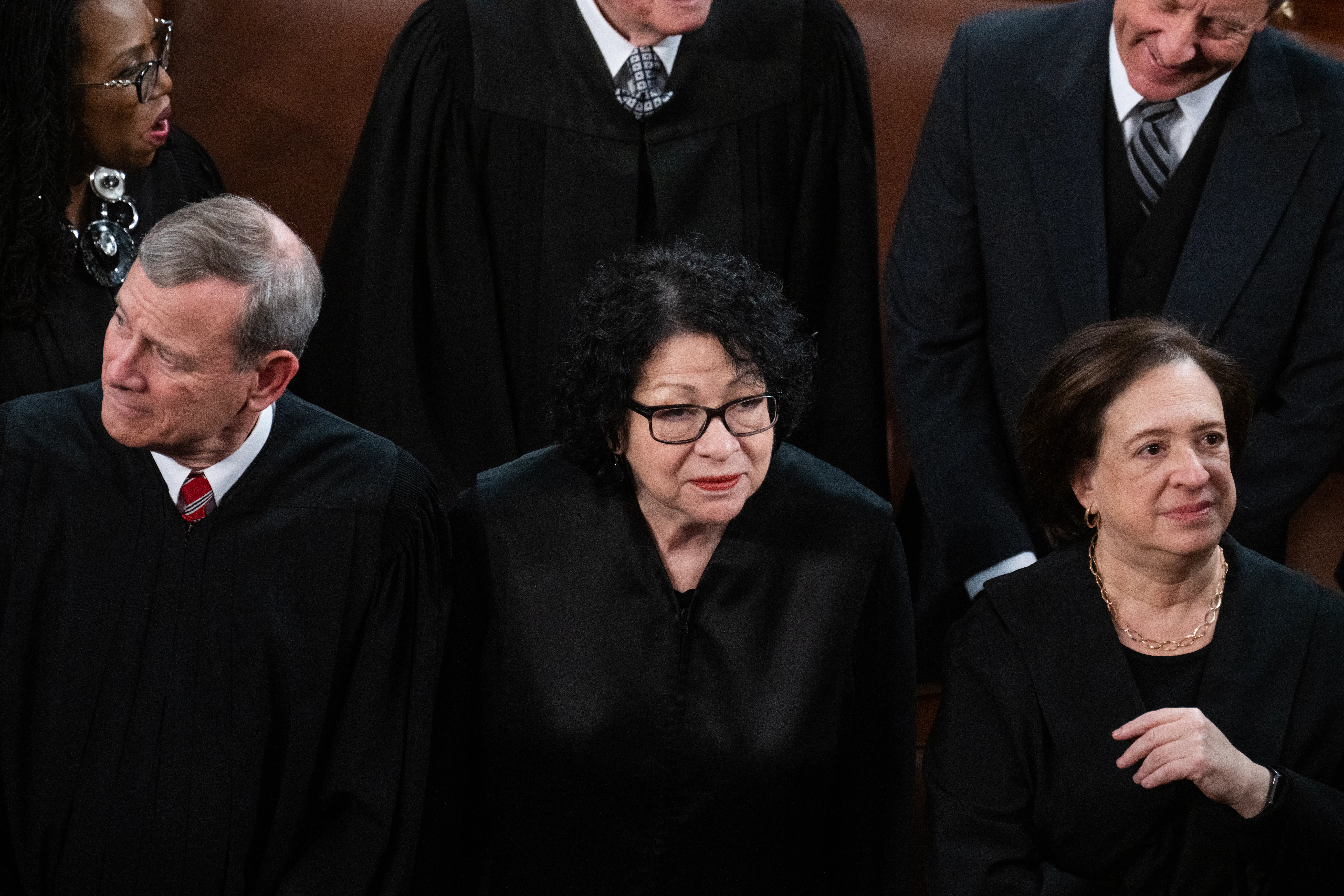 Sonia Sotomayor stands in the middle of Elena Kagan, right, and John Roberts. All are wearing black. 
