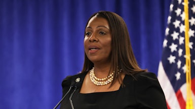 Letitia James speaks at a mic. A U.S. flag is in the background.