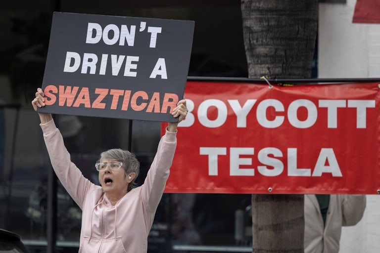 People protest against Elon Musk outside a Tesla dealership