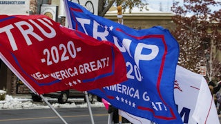 Flags that read "Trump 2020" fly over a street.