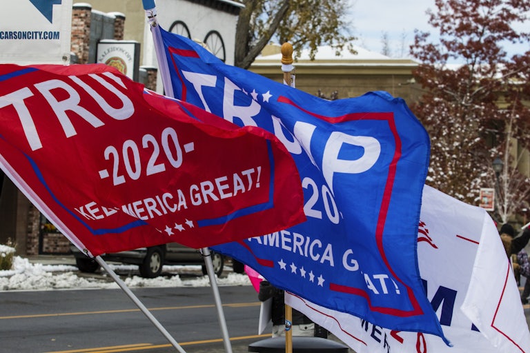 Flags that read "Trump 2020" fly over a street.