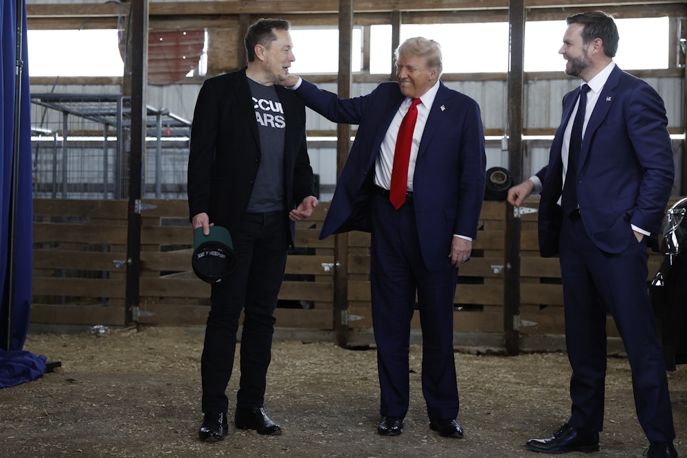 President Donald Trump visits with Elon Musk and JD Vance back stage during a campaign rally.