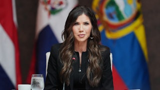 Outgoing Homeland Security Secretary Kristi Noem sits at a table