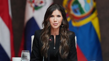 Outgoing Homeland Security Secretary Kristi Noem sits at a table