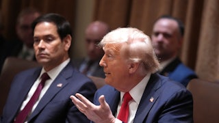 Donad Trump makes an exasperated hand gesture while speaking at his first Cabinet meeting. Marco Rubio in the background stares into space.